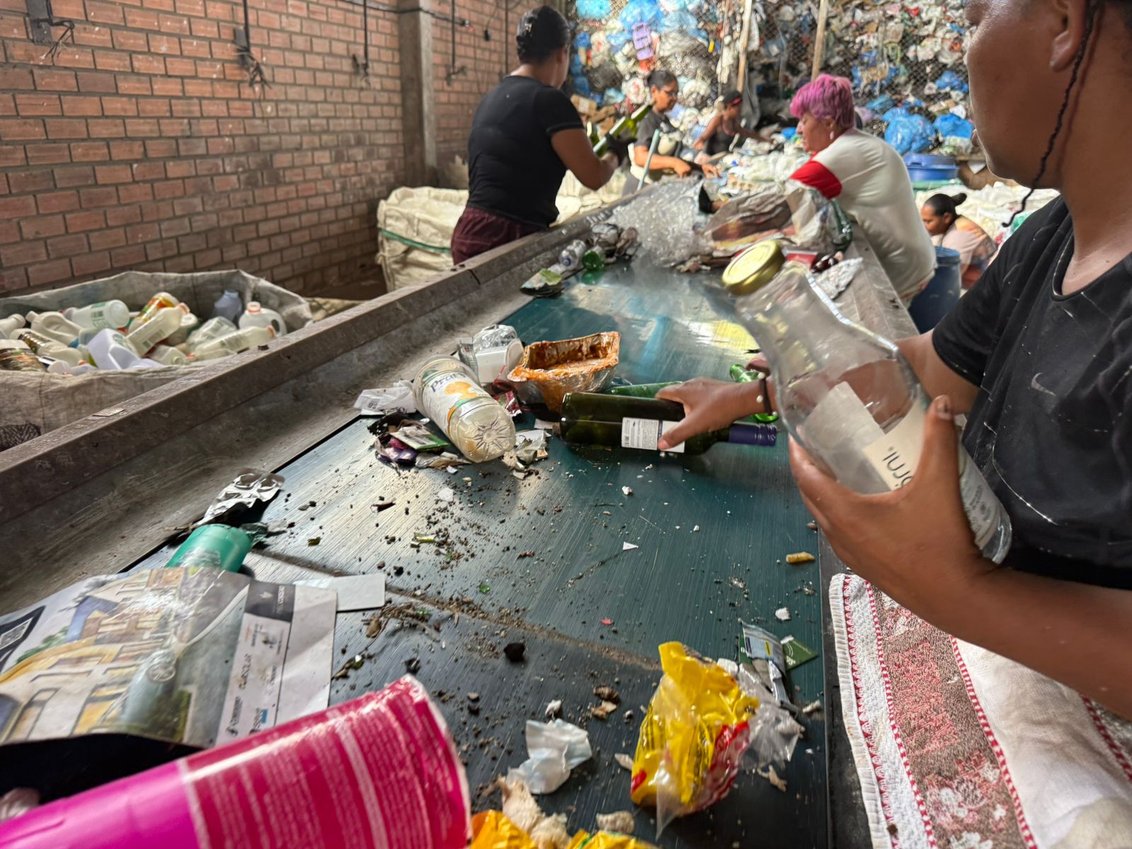 Garrafas de vidro sendo retiradas da esteira